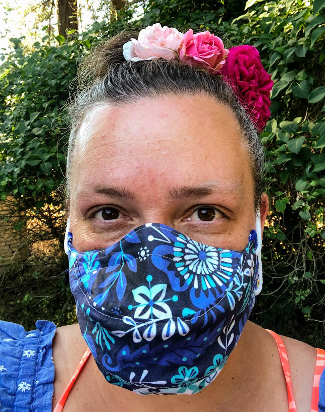 Ronya Lake wearing a blue singers mask with flowers in her hair
