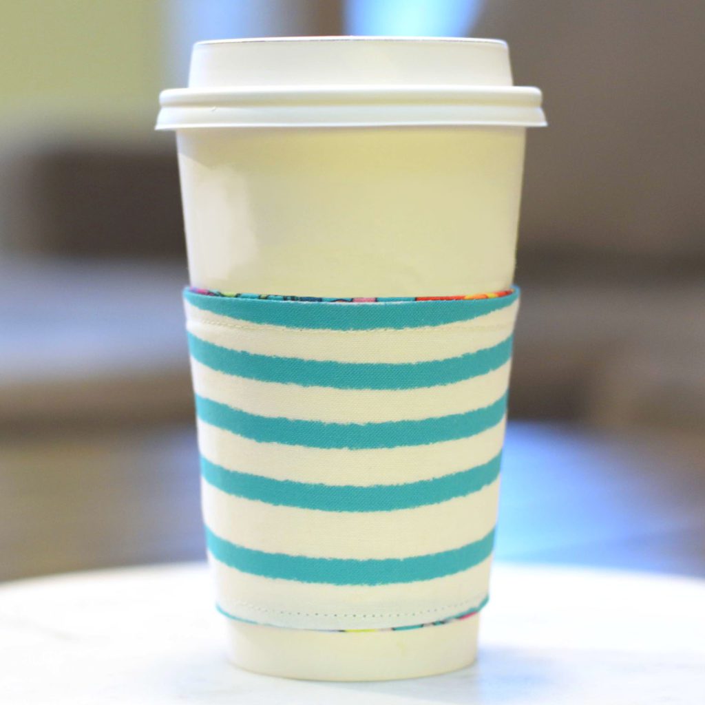 a white coffee cup with a striped sleeve