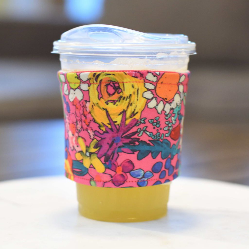 a juice cup with a colorful floral sleeve